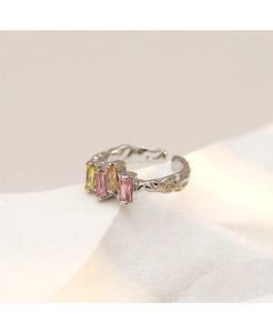 Macro shot of silver ring with colorful rectangular gems and irregular geometric design