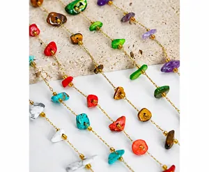 Close-up of bohemian natural stone chip beads in mixed colors on a gold chain necklace