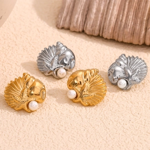 Detailed macro view of 18K gold and silver seashell starfish earrings with white pearls