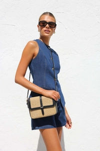 Sac bandoulière en paille avec bordure noire porté avec une tenue en denim bleu foncé