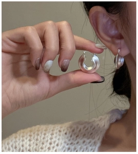 Detail of matte silver chunky hoop earring in S925 sterling silver minimalist style