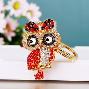 Detail of a sparkling gold owl keychain with red enamel and clear crystal rhinestones