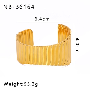 Detalle macro del brazalete ancho en acero chapado en oro 18K con textura de hojas