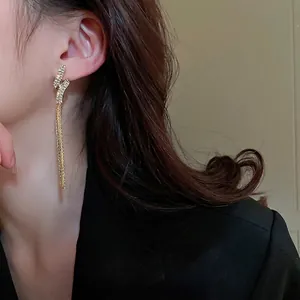 Long geometric twisted tassel earrings in gold with sparkling zircon crystals
