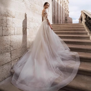 Elegant white long sleeve lace wedding dress with stunning train and open back buttons