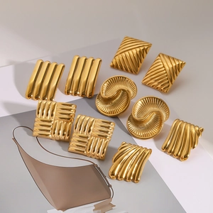 Macro view of assorted geometric gold stainless steel earrings with textured patterns