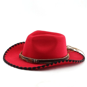 Detail of red wool cowboy hat with black stitched brim and beaded feather ornament