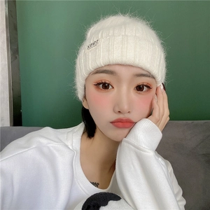 Women's ivory white knitted beanie hat featuring a 1982 California woven patch tag