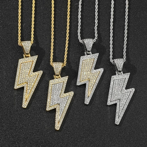 Close-up of gold and silver lightning bolt pendants with pavé rhinestones on twist chains