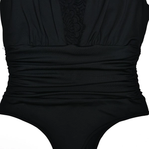 Dettaglio di body nero in pizzo con elegante scollo a V e vita plissettata rifinita