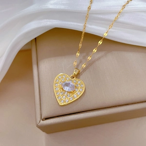 Luxurious gold heart pendant necklace with full pavé crystals on white silk background