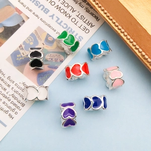 Detail view of colorful heart-shaped enamel beads in multiple colors for DIY jewelry