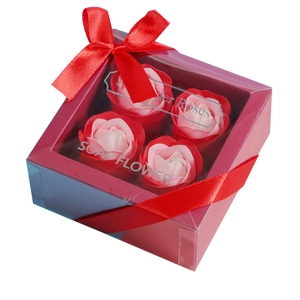 Gift box with four realistic soap roses in red and pink gradients with a ribbon bow