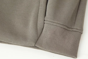 Detailed macro view of the ribbed cuff and soft dark gray knit fabric on the casual hoodie