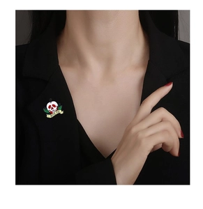 Detail of Bite Me skull enamel pin with green leaves on a black suit lapel