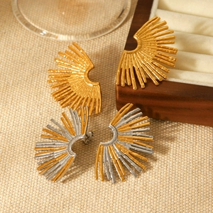 Two pairs of gold and silver fan-shaped stainless steel earrings on a woven texture backdrop