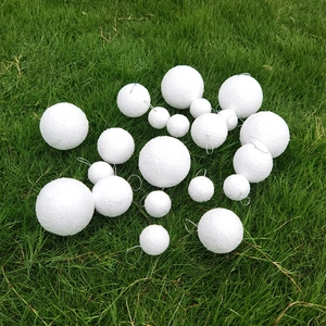 Detailed macro view of white polystyrene foam balls with wire hooks on green lawn
