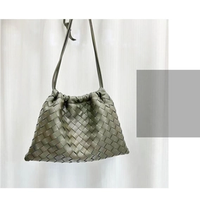 Detail of green woven leather shoulder bag with drawstring closure and fine strap