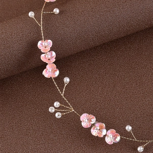 Close-up of handmade bridal headpiece with pink sequin petals and white pearls
