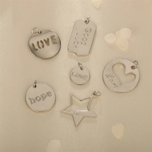 Silver DIY metal pendants in star, circle, and heart shapes with various engravings