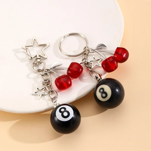 Close-up of black number 8 pool ball keychain with red cherry beads and star charms