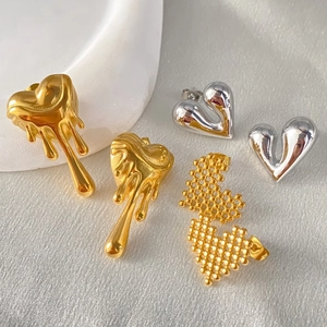Détail de boucles d'oreilles cœur en or et argent avec effets de métal fondu et pixel