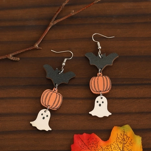 Halloween dangle earrings with wooden bat, pumpkin and ghost charms on wood background