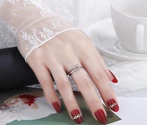Detail shot of a silver crisscross ring with sparkling zircons on a model's finger