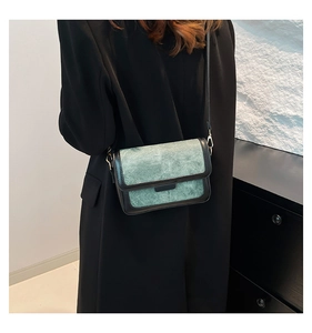 Detail view of a vintage green textured fabric crossbody bag on a model side profile