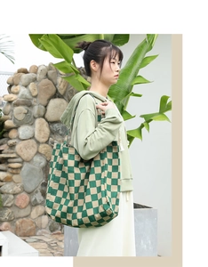 Detail shot of green and beige checkered tote bag in soft corduroy on model