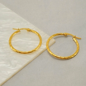 French vintage gold twisted rope hoop earrings for women on elegant marble background