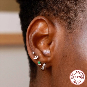 Set of four S925 sterling silver cartilage studs with green gemstones on ear