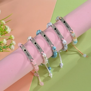 Gros plan de bracelets bébé personnalisés avec plaque gravée et perles colorées