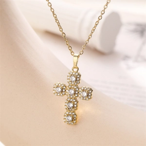 Gros plan du pendentif croix dorée avec zircons cubiques sur un support élégant