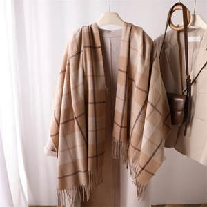 Detail of soft beige and brown plaid cashmere-like scarf with classic fringe edges