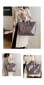Macro view of large grey glossy tote bag with white TOTE BAG text for daily commuting