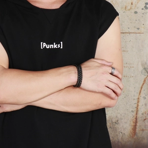 Close-up of black double-row punk chain bracelet and textured silver ring on male model