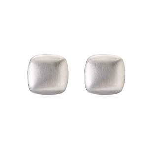 Macro detail of square silver stud earrings featuring a brushed metallic texture finish
