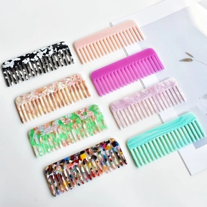 Flat lay showing eight wide-tooth acetate hair combs with marble and tortoiseshell patterns