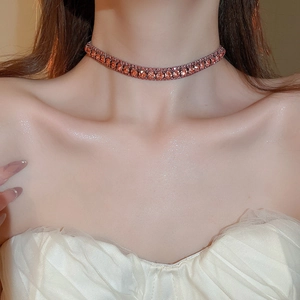 Close-up of a high-quality orange gemstone choker necklace on a professional model