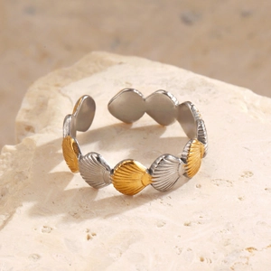 Minimalist shell ring in two-tone gold and silver finish on a natural stone base