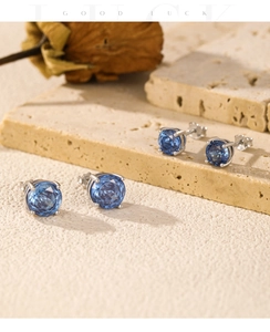 Detailed macro view of royal blue rose cut crystals set in four-prong silver stud earrings