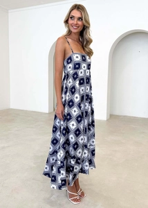 Detailed view of dark blue and white floral print on a long bohemian sundress fabric