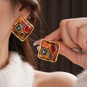 Gros plan sur des boucles d'oreilles vintage avec œil de tigre et ambre sertis