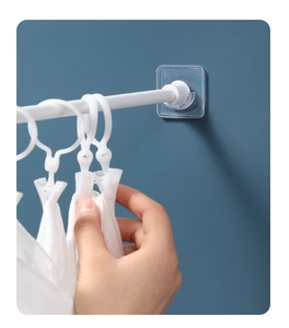 Vue macro de la barre télescopique blanche avec crochets adhésifs transparents