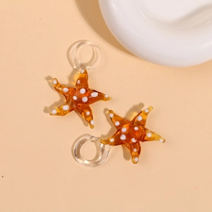 Macro detail of amber glass starfish pendants with white polka dots and clear hooks