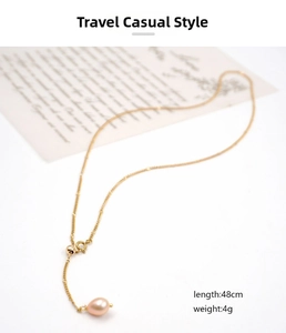 Vue détaillée du collier ajustable en titane doré avec perle rose pendante, longueur 48cm