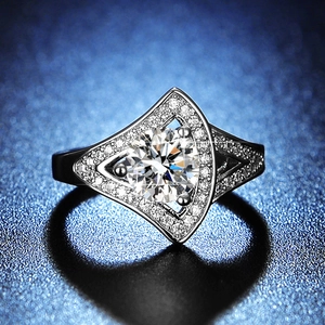 Close-up of silver moissanite ring with six-prong setting and a geometric shield design