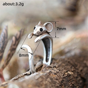Retro silver adjustable mouse ring made of copper shown on a natural bark background