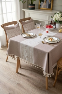 Detailed view of jacquard table runner with reindeer patterns and elegant fringe edge
